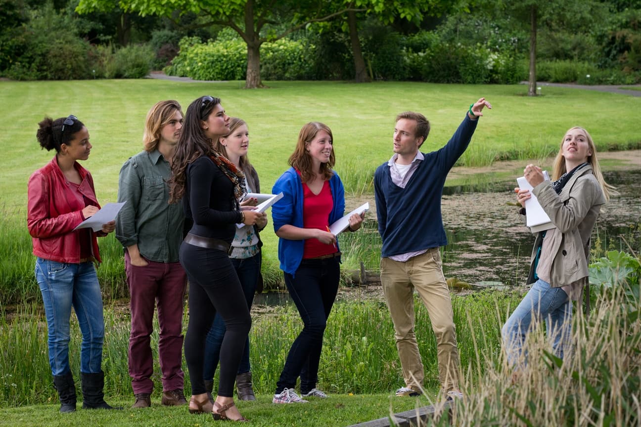 Docent en studenten bij een les in de natuur